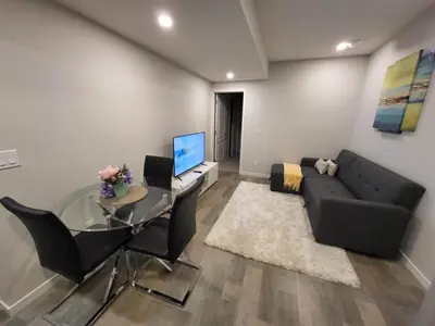 a living room with a glass table and a black couch at Modern 2 Bed Urban Retreat in Calgary