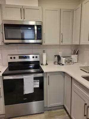 a kitchen with a stove and a microwave at Modern 2 Bed Urban Retreat in Calgary