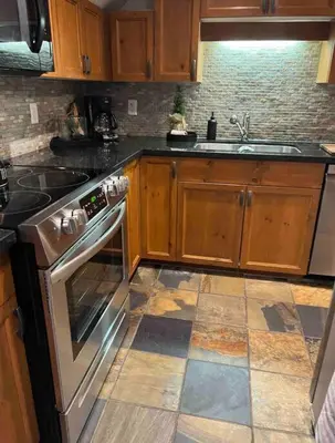a kitchen with a stove and a sink at The Eden Whistler - Luxury 2 BDRM Ski in / Ski out in Whistler