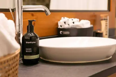 a bottle of wine sitting on a counter next to a sink at The Eden Whistler - Luxury 2 BDRM Ski in / Ski out in Whistler