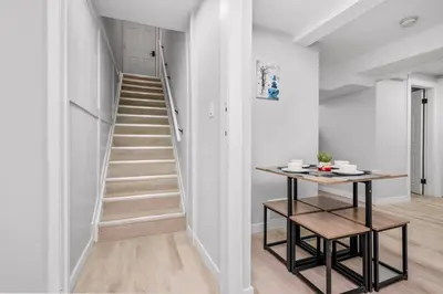 a staircase in a white room with a table at CenterStreet-Cozy 2bedroomSuite in Calgary