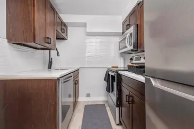 a kitchen with wooden cabinets and stainless steel appliances at CenterStreet-Cozy 2bedroomSuite in Calgary