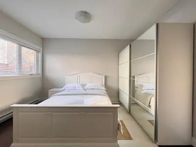 a bedroom with a white bed and a mirror at Spacious Home in Richmond in Richmond
