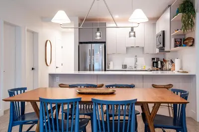 a kitchen with a wooden table and blue chairs at Powder Pines Retreat by Revelstoke Vacations in Revelstoke