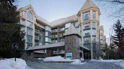 a large apartment building with snow in front of it at Woodrun Lodge 517 | Large Ski-In Ski-Out Condo by Upper Village w/ Mountain Views & Shared Hot Tub in Whistler