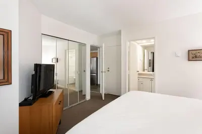 a bedroom with a bed and a tv and a mirror at Woodrun Lodge 414 | Cozy Ski-In Ski-Out Condo w/ Shared Hot Tub, Pool, Fireplace, & Parking in Whistler