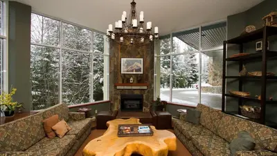 a living room with couches and a table and a fireplace at Woodrun Lodge 414 | Cozy Ski-In Ski-Out Condo w/ Shared Hot Tub, Pool, Fireplace, & Parking in Whistler