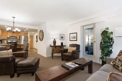 a living room with a couch and a table at Woodrun Lodge 414 | Cozy Ski-In Ski-Out Condo w/ Shared Hot Tub, Pool, Fireplace, & Parking in Whistler