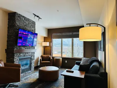 a living room with a couch and a fireplace at Canmore Mountain Retreat - Heated Pool & Hot-tub in Canmore