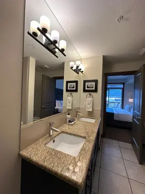 a bathroom with a sink and a large mirror at Canmore Mountain Retreat - Heated Pool & Hot-tub in Canmore