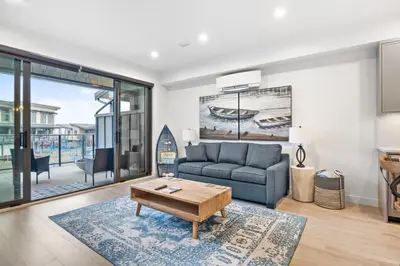 a living room with a couch and a table at Seas The Day Saratoga at THE BEACH HOUSE in Campbell River
