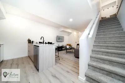 a staircase leading up to a kitchen and a living room at Modern Suite King Bed Near Whyte Ave and U of A WIFI in Edmonton