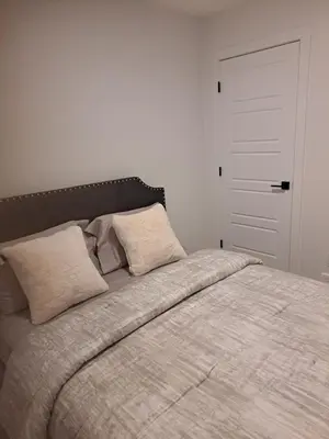 a bedroom with a large bed with two pillows at PeaceHouse for females only - Business visits in Calgary