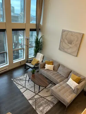 a living room with two couches and a table at Modern top-floor 1-bedroom loft with free parking in Vancouver