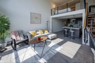 a living room with a couch and a table at Modern top-floor 1-bedroom loft with free parking in Vancouver