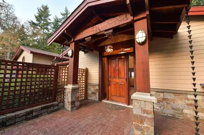 a house with a wooden door and a fence at Dolphin House by EMR Vacation Rentals in Nanoose Bay