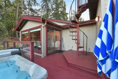 a house with a red deck with a hot tub at Dolphin House by EMR Vacation Rentals in Nanoose Bay