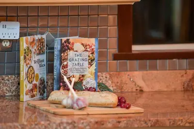 a cutting board with a loaf of bread and some books at Dolphin House by EMR Vacation Rentals in Nanoose Bay