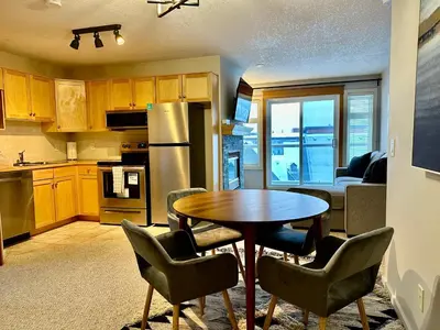 a kitchen with a table and chairs and a kitchen with a couch at W400 Mountain Surround Top Floor Canmore Vacation in Canmore