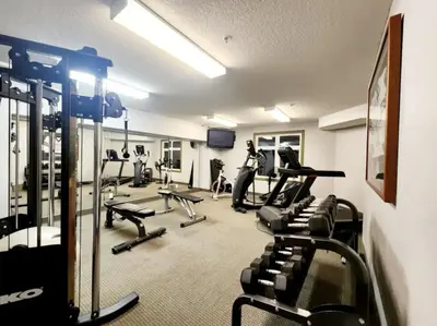a gym with several treadmills and cardio machines at W400 Mountain Surround Top Floor Canmore Vacation in Canmore