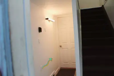 a hallway with a staircase and a door with a rainbow on the wall at Yellowknife Downtown 50a avenue Retreat in Yellowknife