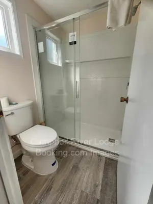 a bathroom with a toilet and a glass shower at Campbell River Lodge in Campbell River