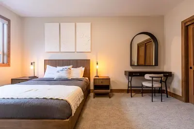 a bedroom with a bed and a desk and a mirror at Polar Peak Lodges by Fernie Central Reservations in Fernie
