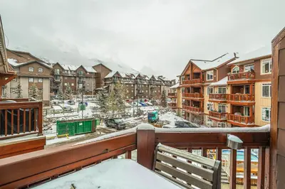 a balcony with a view of a snow covered city at Romantic Mountain Escape - Hot Tubs & Private Balcony! managed by Little Sister Getaways in Canmore