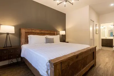 a bedroom with a large bed with white sheets at Powder House Chalet by Fernie Central Reservations in Fernie