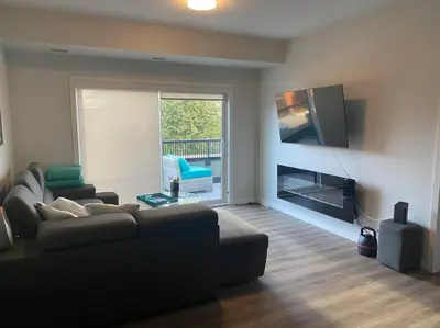 a living room with a couch and a flat screen tv at Spacious 2-bed, 2-bath condo in downtown Kelowna! in Kelowna