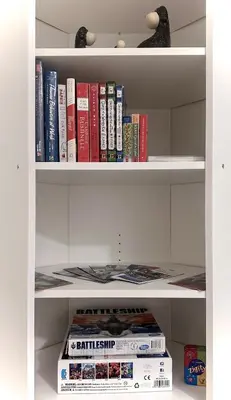 a white book shelf filled with books at Blissful Stay in Surrey in Surrey