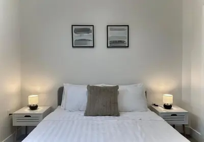 a bedroom with a white bed with two night stands at Blissful Stay in Surrey in Surrey