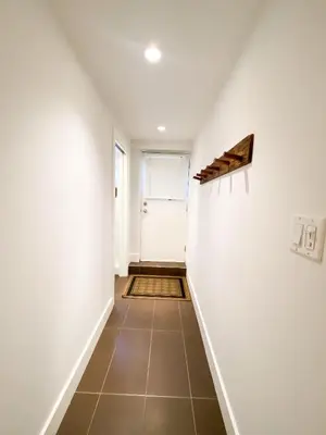 a hallway with white walls and a tile floor at Small Private Studio at Kitsilano Beach in Vancouver