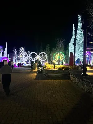 a person walking down a street at night with lights at Cascade Lodge with front desk check in services, ski valet service, boot and glove dryer, 2 hot tubs, year round heated pool, gym, sauna, change rooms & showers, WIFI, cable TV in Whistler