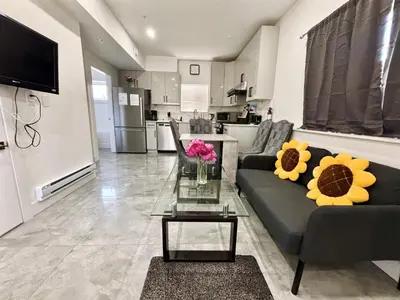 a living room with a couch and a table with flowers at Vancouver’s Homey Laneway House in Vancouver
