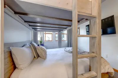 a room with a loft bed with a couch at Central 2BR with Prime Amenities in Whistler