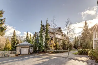 a large house with a garage in front of a street at Central 2BR with Prime Amenities in Whistler