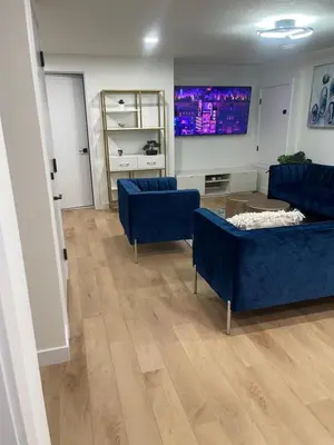 a living room with two blue couches and a tv at Stylish 2 Bedroom suite in SW Edmonton close to Windermere and Edmonton International Airport in Edmonton