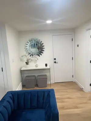a living room with a blue couch and a mirror at Stylish 2 Bedroom suite in SW Edmonton close to Windermere and Edmonton International Airport in Edmonton