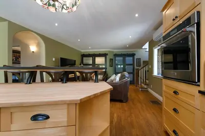 a kitchen with a table and a living room at Character Stay across Swan Lake Nature Sanctuary in Victoria
