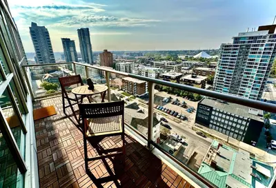 a balcony with two chairs and a table on a building at ColoursNest - Downtown apt spectacular view and location in Calgary