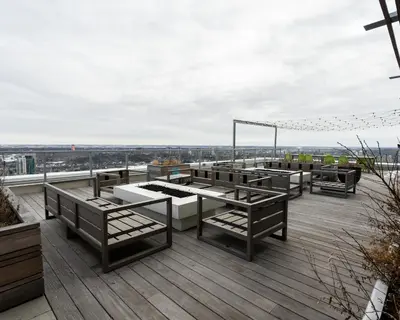 a rooftop deck with tables and benches on a building at Hendrix Luxury Apartments by Corporate Stays in Edmonton