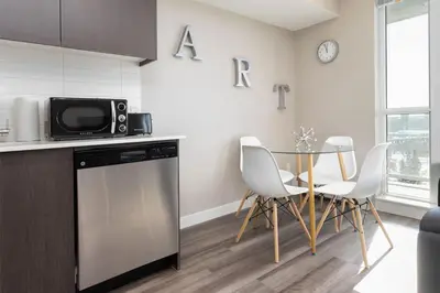 a kitchen with a table and chairs and a microwave at Hendrix Luxury Apartments by Corporate Stays in Edmonton