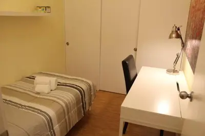 a bedroom with a bed and a desk with a lamp at The Niven Lake Retreat in Yellowknife