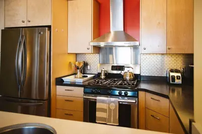 a kitchen with a stove and a stainless steel refrigerator at The Niven Lake Retreat in Yellowknife