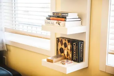 a book shelf filled with books next to a window at The Niven Lake Retreat in Yellowknife