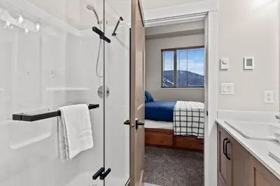 a bathroom with a shower and a bedroom at Powder Heights #18 townhouse in Sun Peaks