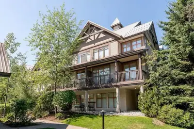 a large house with a balcony and trees at Beautiful 1BR 1BA Apartment at NORTHSTAR-Whistler, BC in Whistler