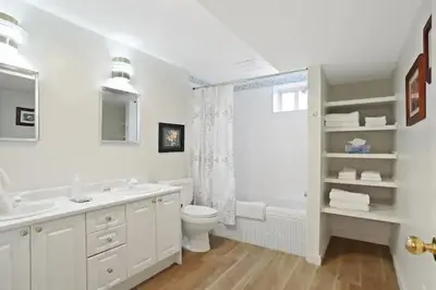 a white bathroom with a toilet and a sink at Uncork and Unwind in West Kelowna