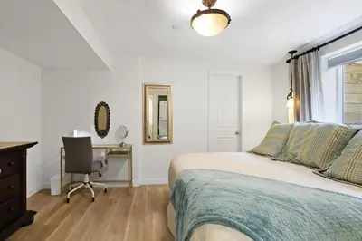 a bedroom with a bed and a desk and a chair at Uncork and Unwind in West Kelowna